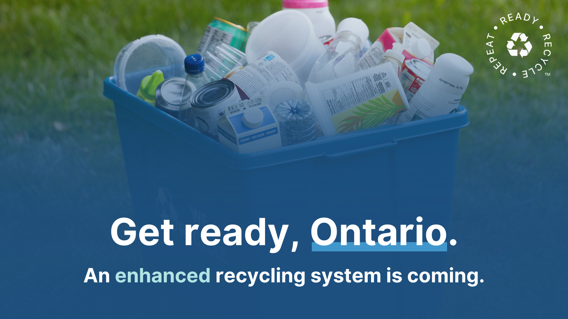 blue box on field of grass with clean loose recyclable materials with English text Get ready Ontario