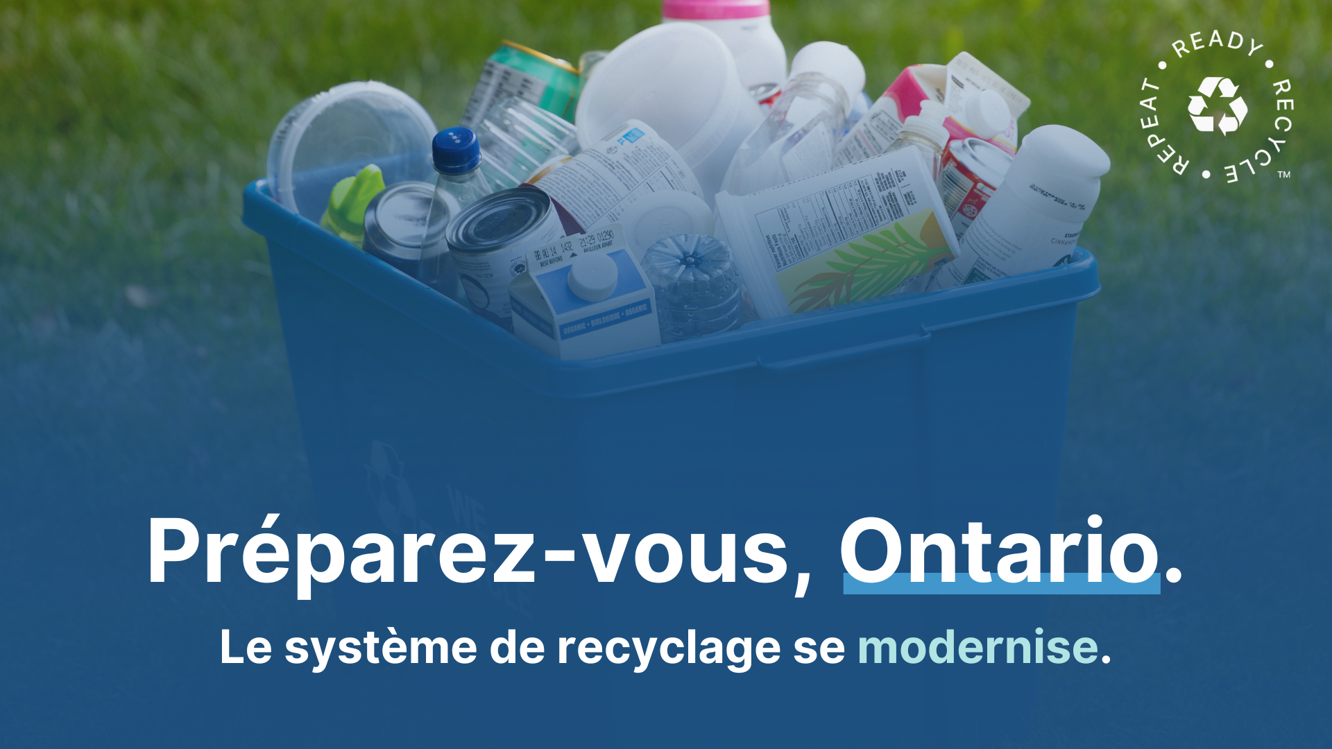 boîte bleue sur un champ d'herbe avec des matériaux recyclables propres et en vrac avec texte en anglais Get ready Ontario